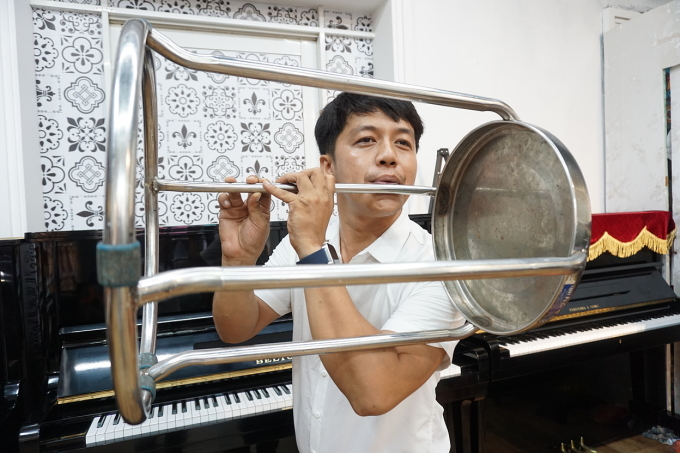 Từ chiếc ghế inox, anh Trịnh Ngọc Huy Toàn chế tác thành chiếc sáo độc lạ trình diễn tại nhà, quận Sơn Trà, TP Đà Nẵng. Ảnh: Nhân vật cung cấp.